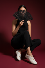Egyptian model sitting with cream ballet flats and anklet