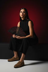 Egyptian model sitting with tan suede loafers and anklet