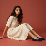 Model seated – navy ballet flats